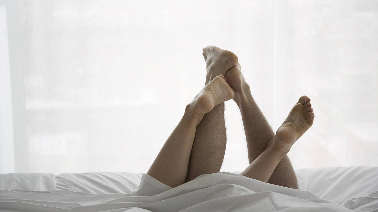 Ноги мужчины и женщины в постели
